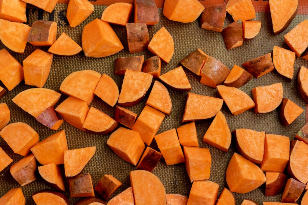 cut sweet potatoes on a baking tray