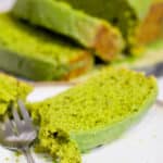 Green matcha pound cake on a gray stone slab and plate with slice and fork
