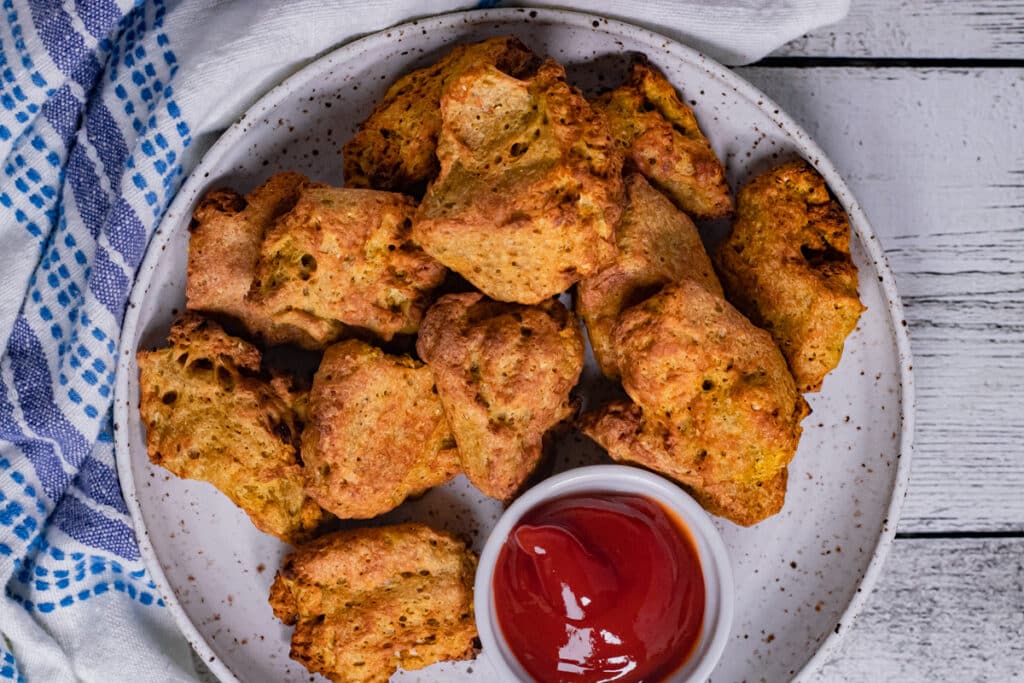Vegan seitan chicken nuggets on a plate with ketchup