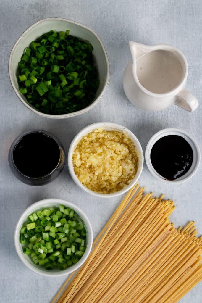 Garlic, green onions, soy sauce and coconut cream on a table