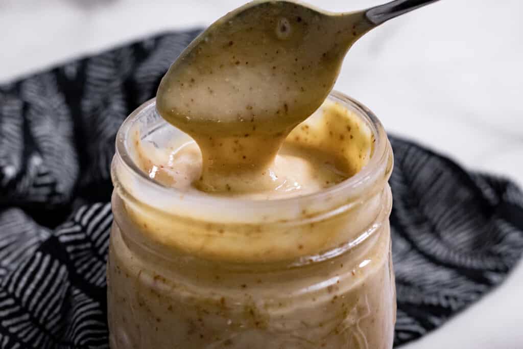 Spoon dipping into a jar of dressing
