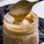 Spoon dipping into a jar of dressing