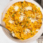 Bowl of Pumpkin Risotto with a spoon in it.