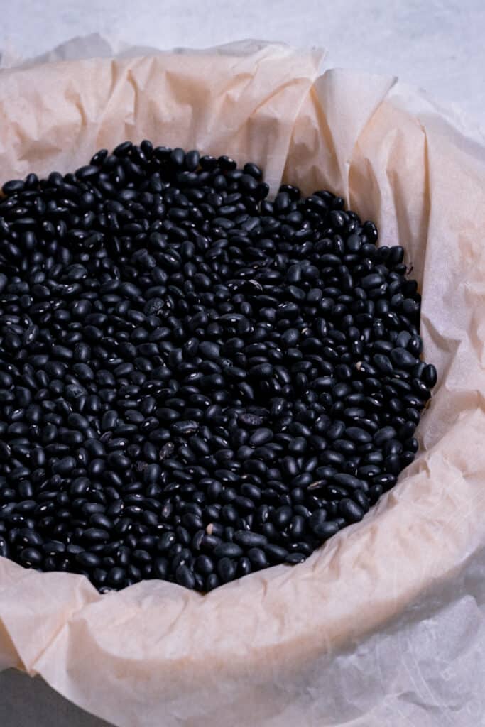 Black beans in a pie shell, separated by parchment paper