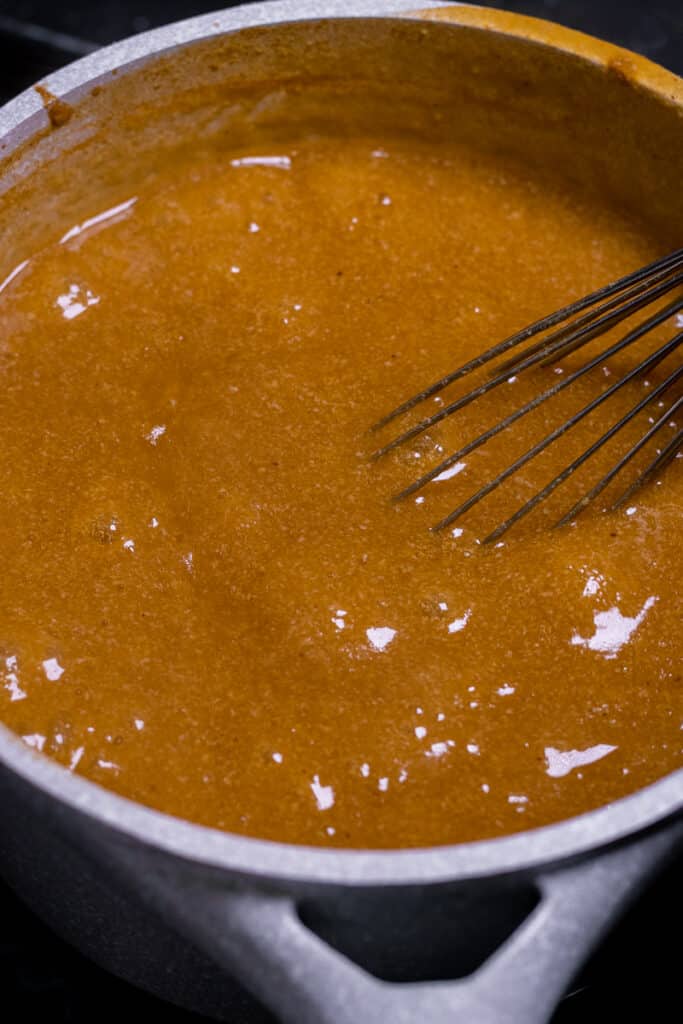 Gravy cooking in a pot with whisk