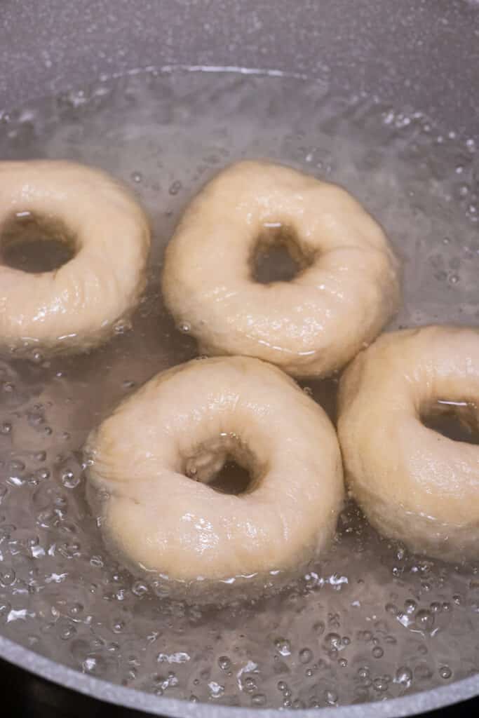 Bagels boiling in a pot of water