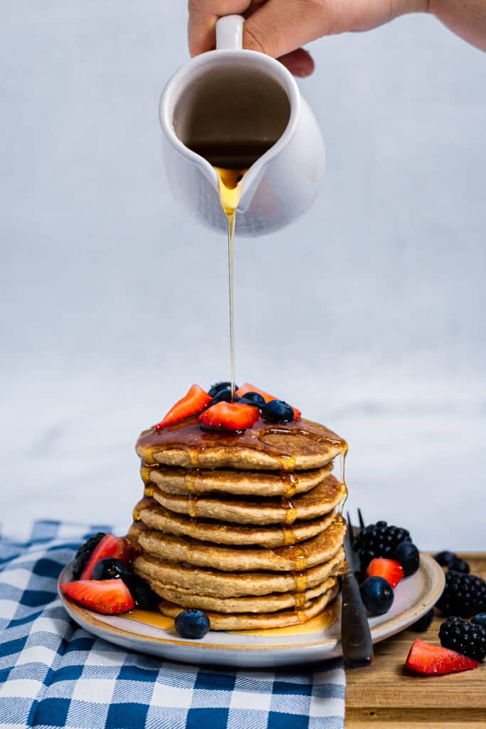 Maple Syrup being poured on plant-based pancakes