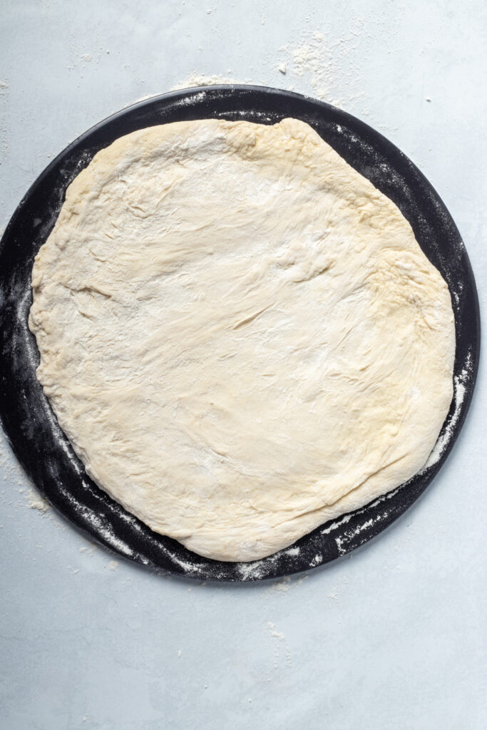 Placing the pizza dough on a pizza stone