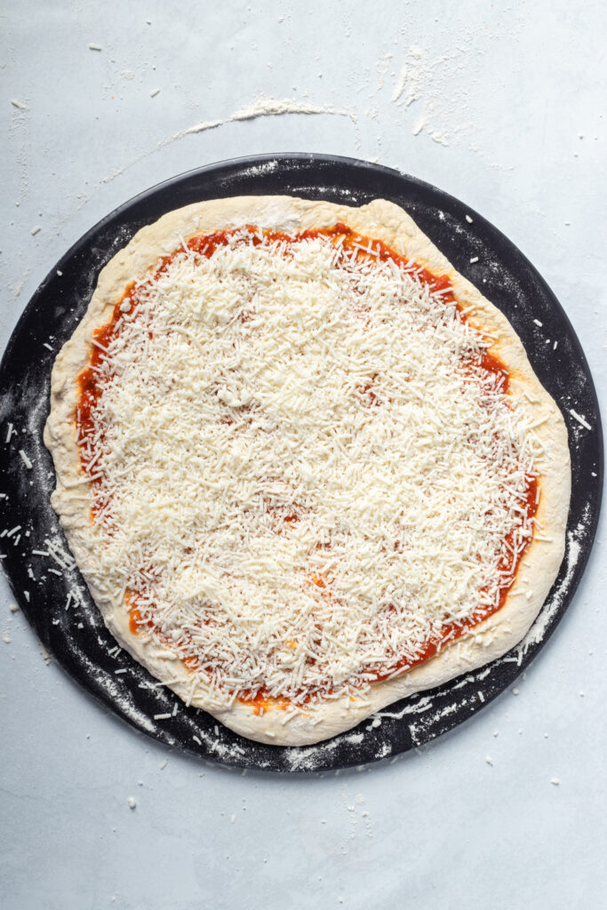 Pizza dough now topped with cheese