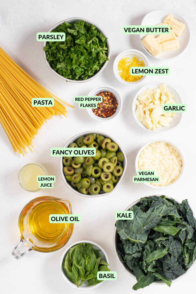 Labeled vegan aglio e olio ingredients in small white bowls on a white counter.