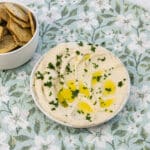 Butter bean hummus on a plate with oil on top and crackers.