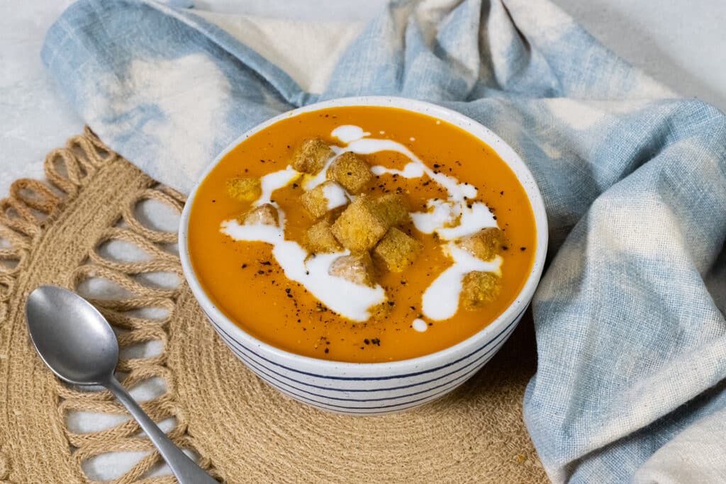 Carrot and Red Pepper Soup in a bowl with crispy tofu.