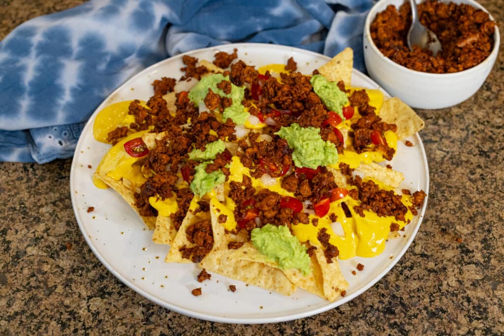 Vegan nachos on a plate with tofu ground beef.